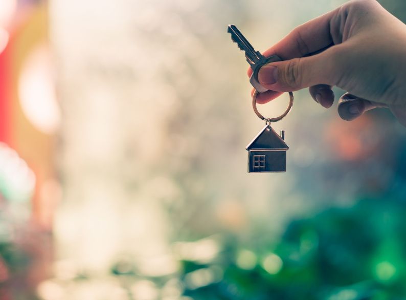 Person holding key to a new home