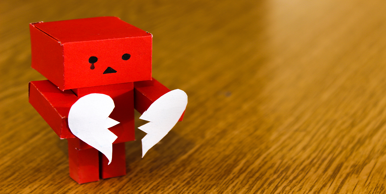 paper robot holding a paper broken heart