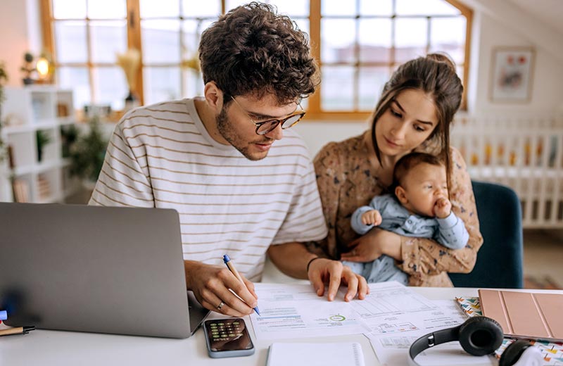 Young couple and baby looking at finances.