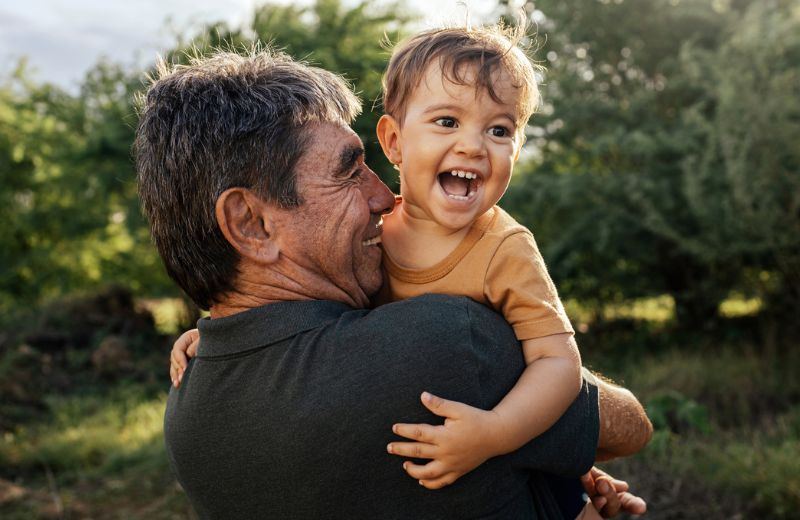 Grandfather and grandson smiling and hugging