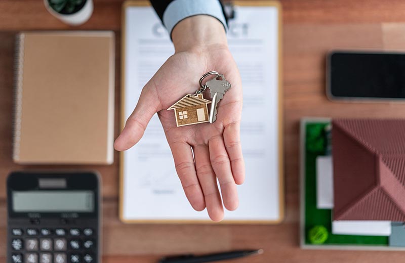 Hand with house key and other documents
