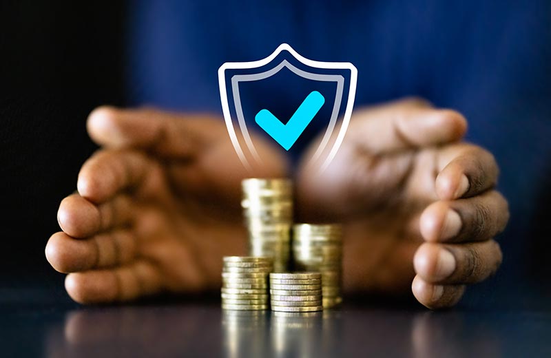 Hands around coin stacks with shield image