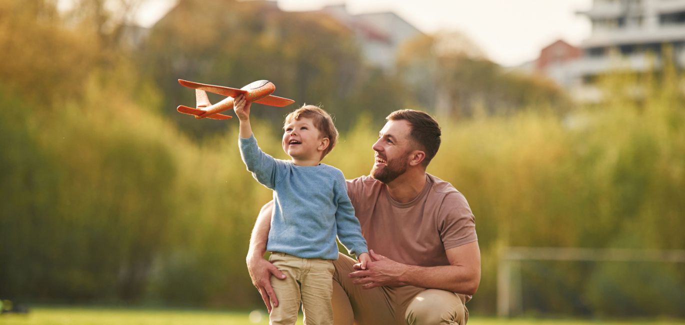 Dad and son flying toy airplane