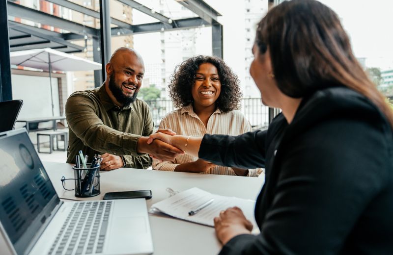 Shaking hands at business table