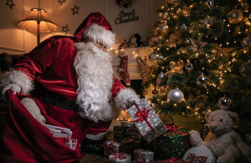 Santa putting presents under tree