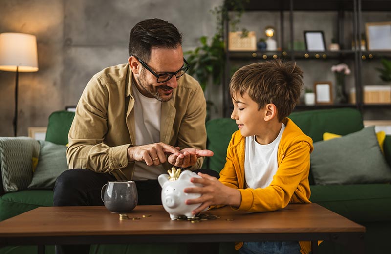 Father and son with piggy bank