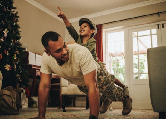 military dad doing push ups with kid on his back