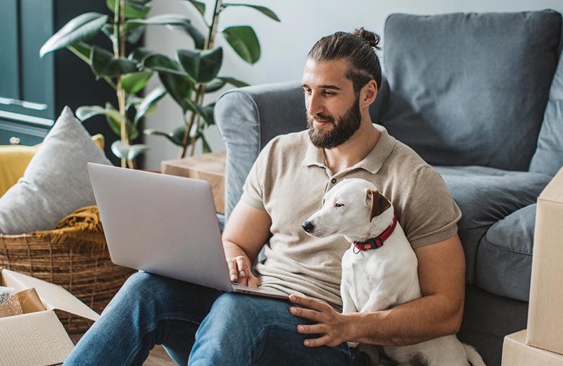 Man and dog using laptop