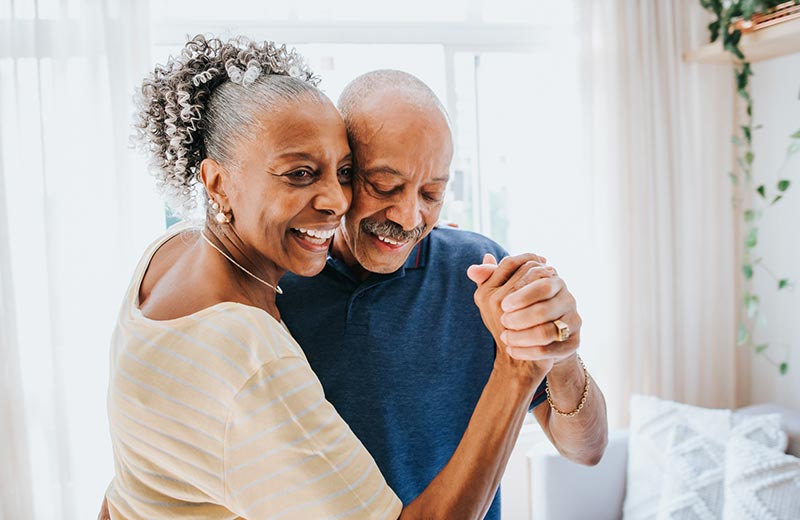 Mature couple dancing at home