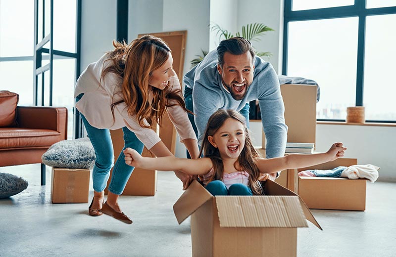Parents pushing kid in cardboard box
