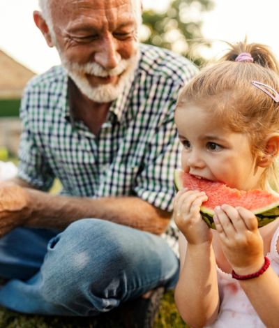 grandpa and grandaughter enjoying watermelon together
