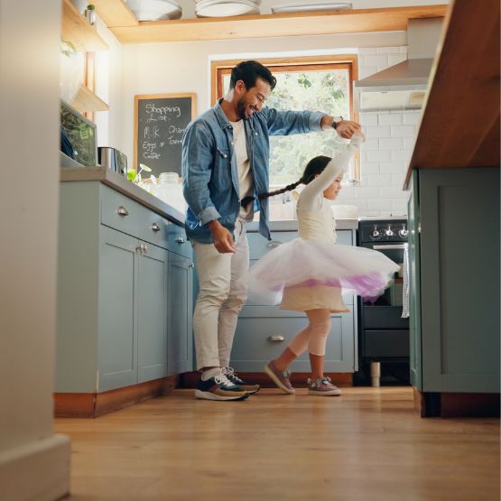Dad and daughter dancing in kitchen