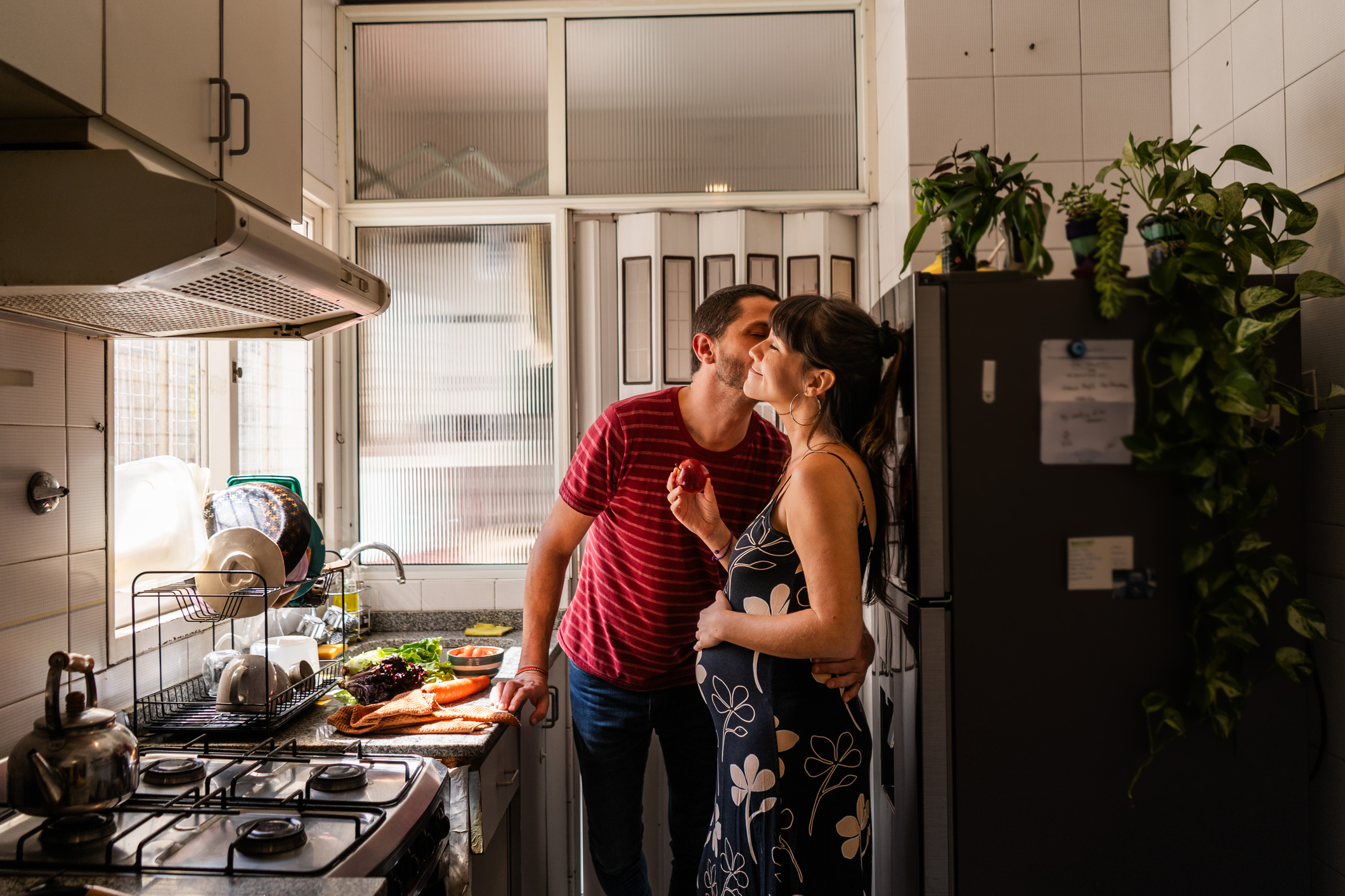 couple expecting baby cooking in kitchen 