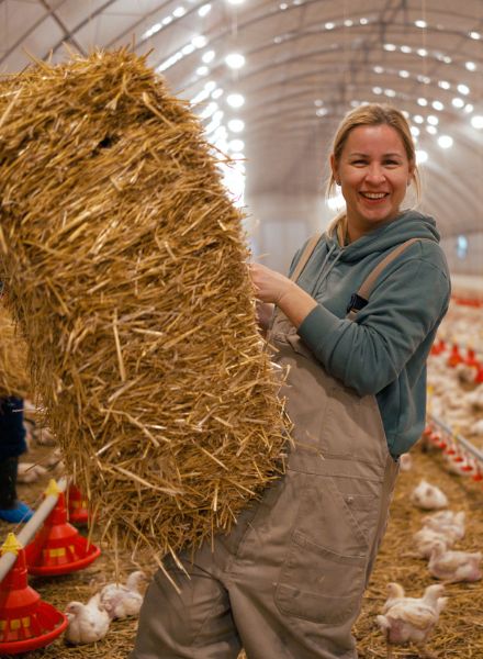 woman bringing in hay to chicken house