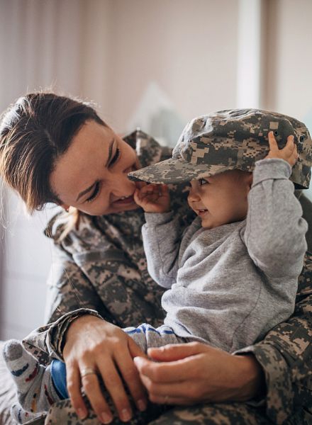baby trying on moms military hat