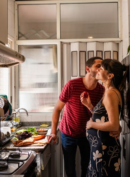 couple expecting baby cooking in kitchen